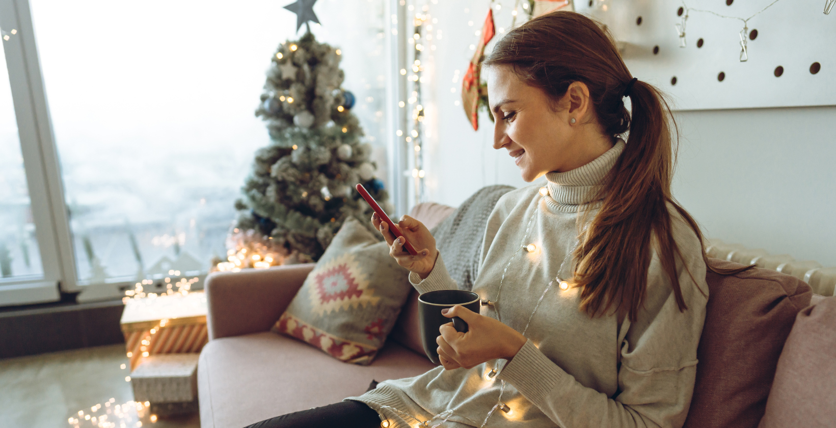 woman on her phone shopping around Christmas time as a result of a franchises marketing strategy for holidays