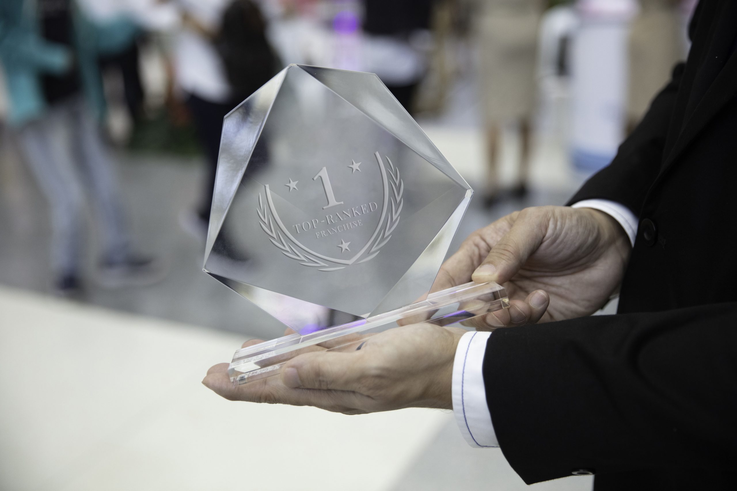 person holding a crystal trophy with a 1 on it