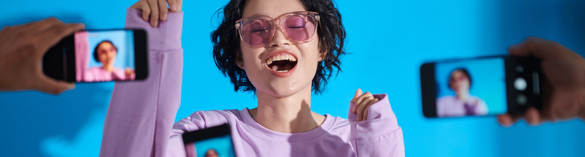 a social media influencer dances while 3 fans record her on their camera phones