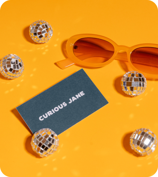 A Curious Jane business card surrounded by disco balls.