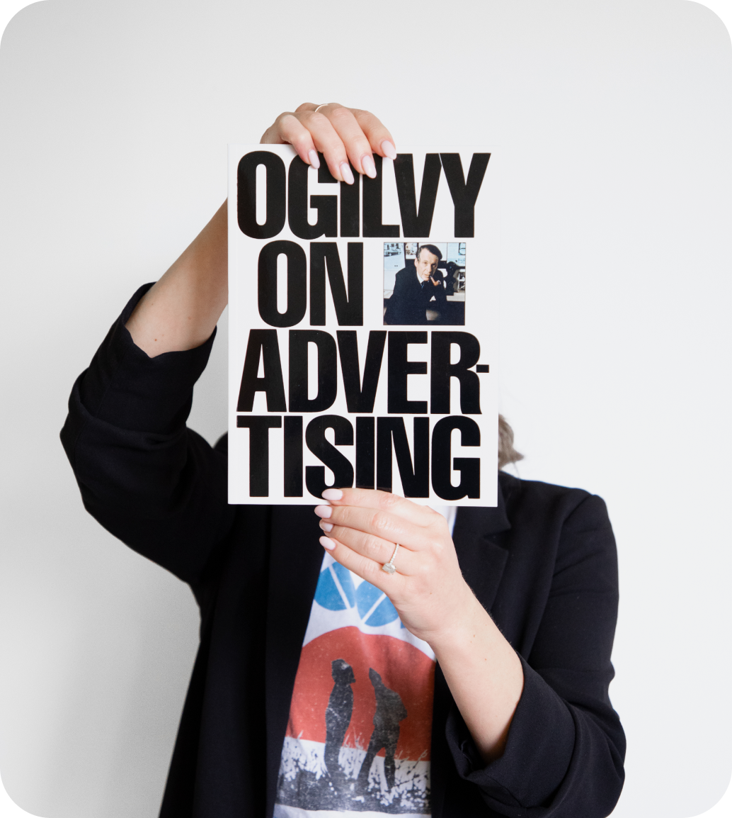 A team member holding a copy of Ogilvy on Advertising.